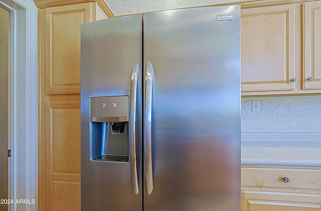 room details with stainless steel refrigerator with ice dispenser and light brown cabinets