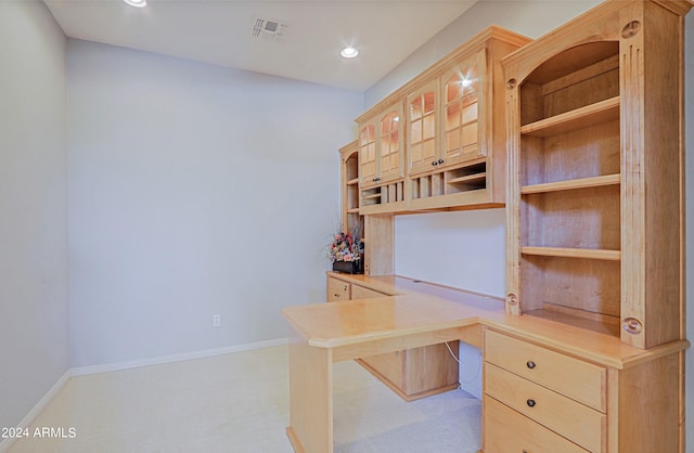 unfurnished office with light carpet and built in desk