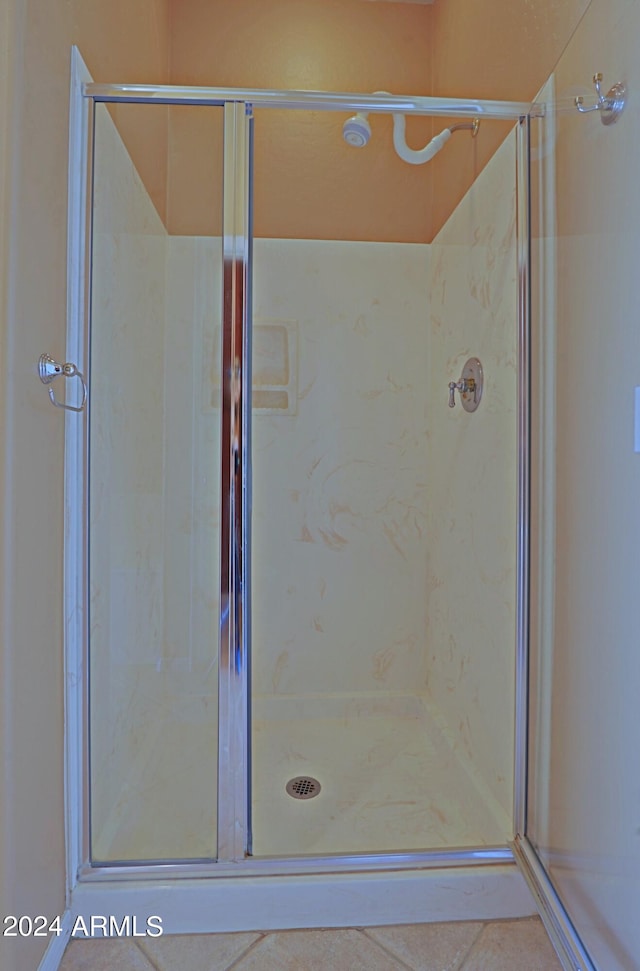 bathroom featuring an enclosed shower and tile patterned floors