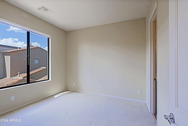 spare room featuring light colored carpet