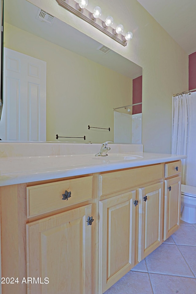 bathroom with walk in shower, vanity, tile patterned flooring, and toilet