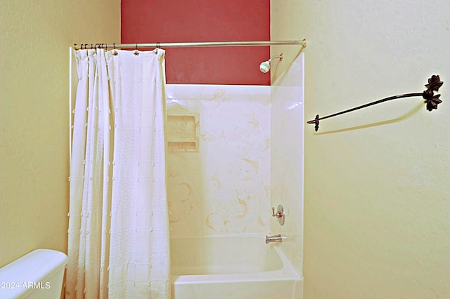 bathroom with shower / tub combo and toilet