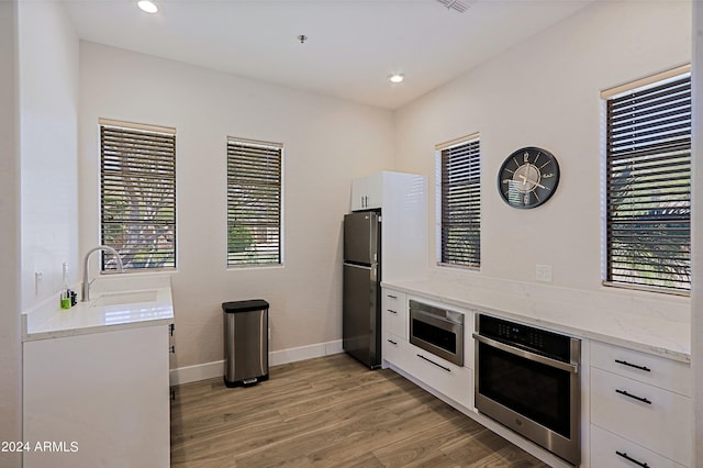 kitchen featuring white cabinetry, appliances with stainless steel finishes, and a healthy amount of sunlight