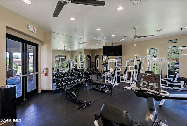 exercise room featuring ceiling fan, a healthy amount of sunlight, and a textured ceiling