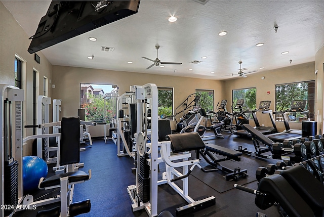 gym with ceiling fan and a textured ceiling