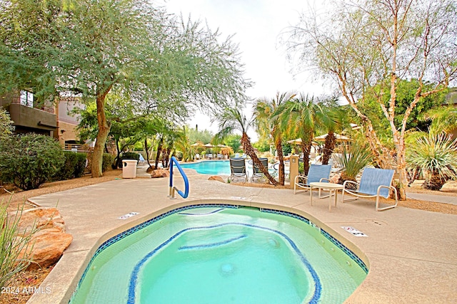 view of pool with a community hot tub and a patio area