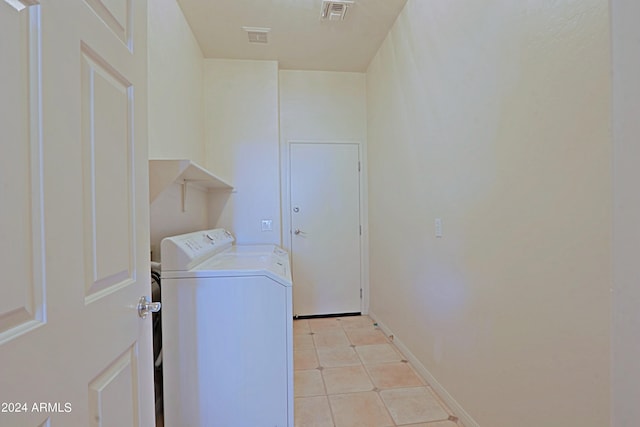 laundry room featuring washing machine and clothes dryer and light tile patterned floors