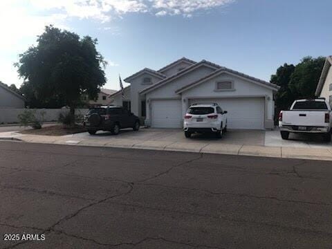 5423 W Topeka Dr, Glendale, AZ 85308 - view of front facade with an attached garage, a tile roof, and driveway