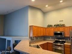 5423 W Topeka Dr, Glendale, AZ 85308 - kitchen featuring brown cabinets, a peninsula, stainless steel appliances, and light countertops