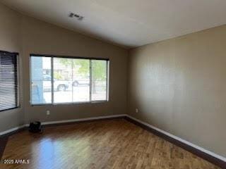 5423 W Topeka Dr, Glendale, AZ 85308 - spare room with visible vents, wood finished floors, baseboards, and vaulted ceiling
