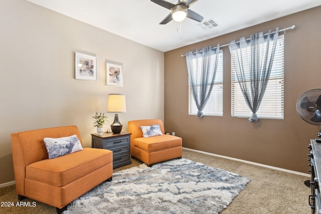 living area with ceiling fan, plenty of natural light, and carpet floors