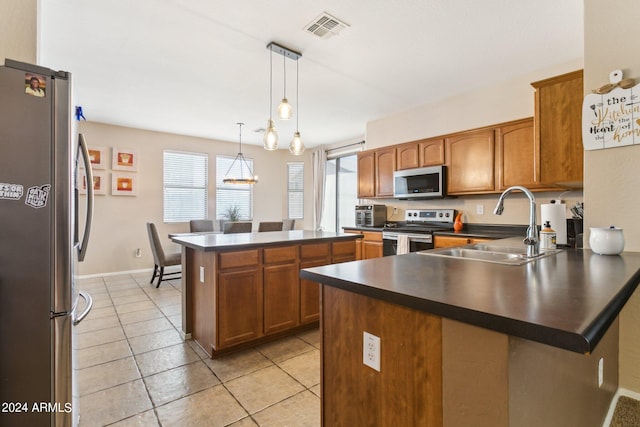 kitchen featuring stainless steel appliances, hanging light fixtures, a healthy amount of sunlight, and sink