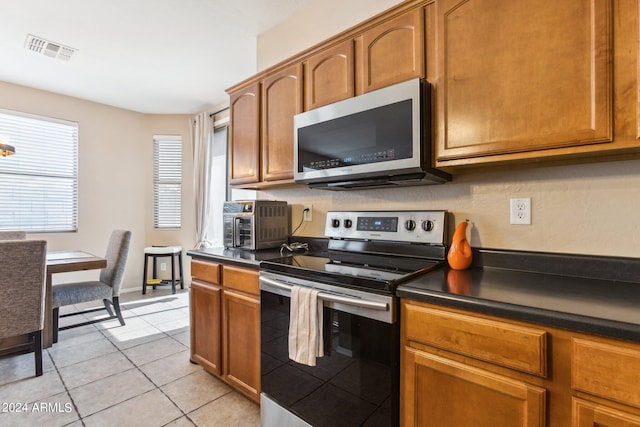 kitchen with appliances with stainless steel finishes and light tile patterned floors