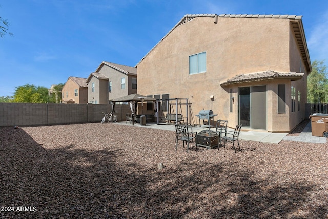 rear view of house with a patio area and an outdoor fire pit