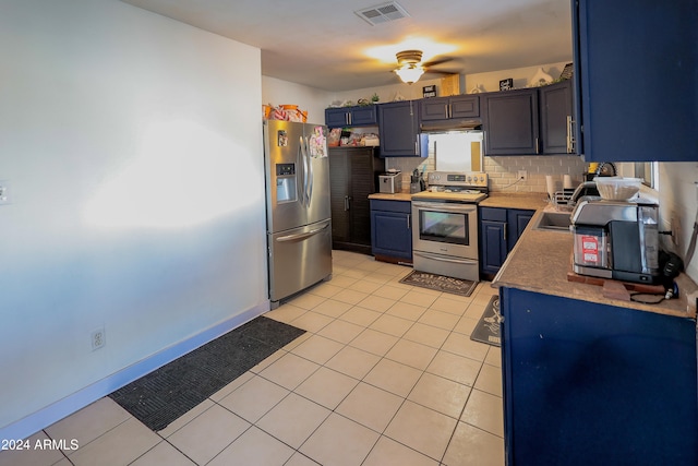 kitchen with blue cabinets, light tile patterned floors, ceiling fan, backsplash, and appliances with stainless steel finishes