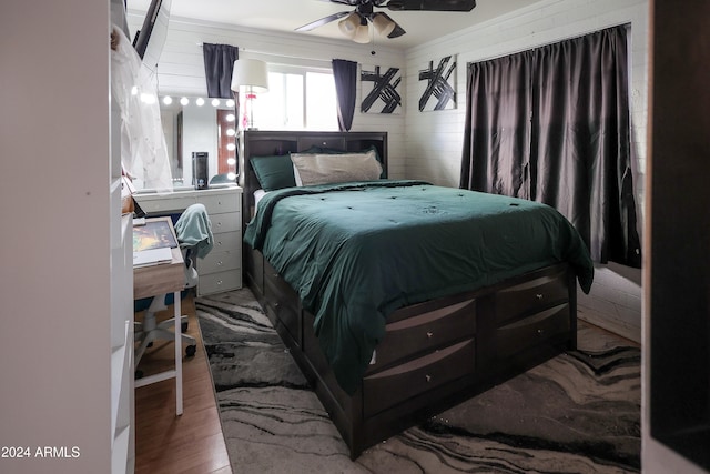 bedroom featuring ceiling fan, light hardwood / wood-style flooring, and ornamental molding