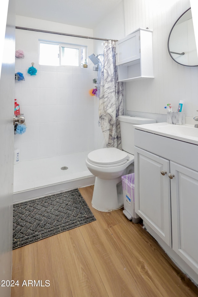 bathroom with walk in shower, vanity, hardwood / wood-style flooring, and toilet