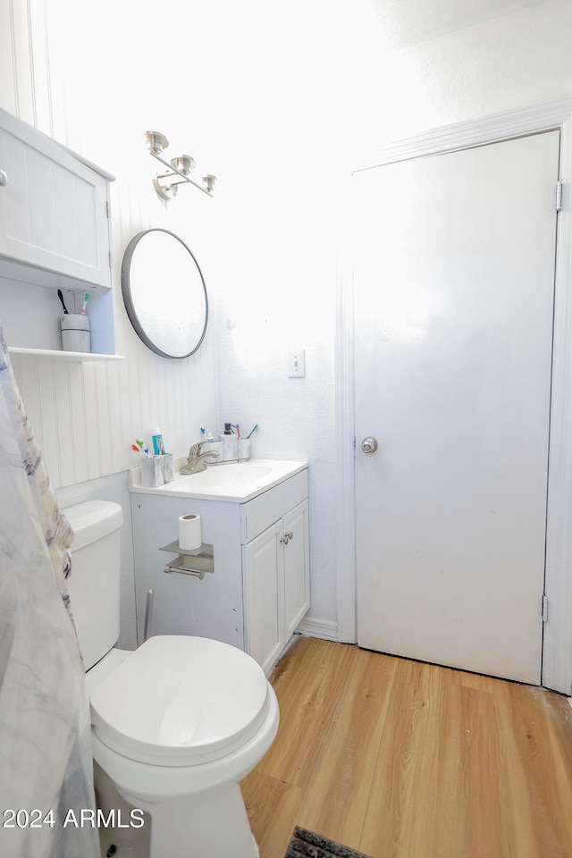 bathroom featuring toilet, vanity, and wood-type flooring