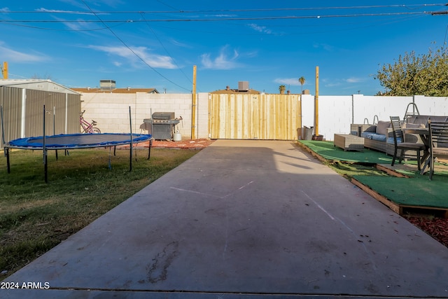 view of yard featuring a shed, a trampoline, and a patio