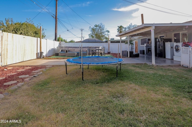 view of yard featuring washer / dryer, a patio, and a trampoline