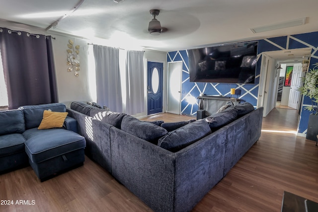 living room with dark wood-type flooring and ceiling fan