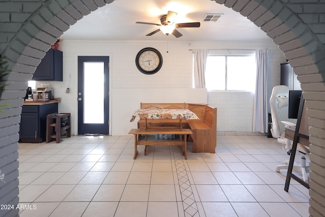 dining room with light tile patterned floors, crown molding, and ceiling fan