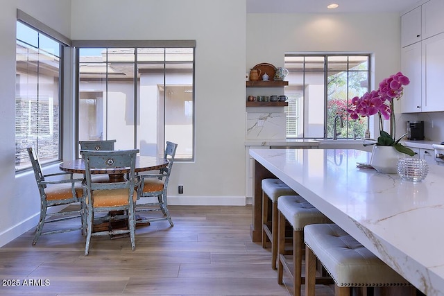 dining space with sink and light wood-type flooring