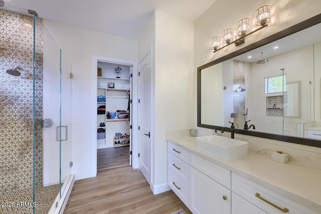 bathroom featuring hardwood / wood-style flooring, vanity, and a shower with shower door