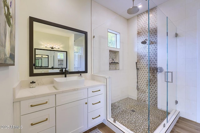 bathroom with hardwood / wood-style flooring, vanity, and an enclosed shower