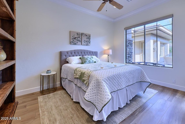 bedroom with crown molding, hardwood / wood-style floors, and ceiling fan