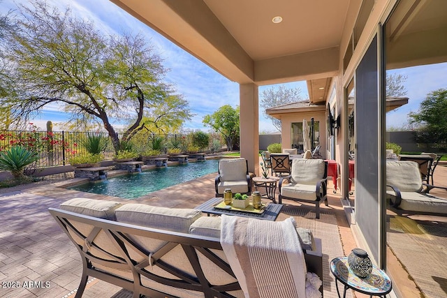 view of pool featuring outdoor lounge area, pool water feature, and a patio area