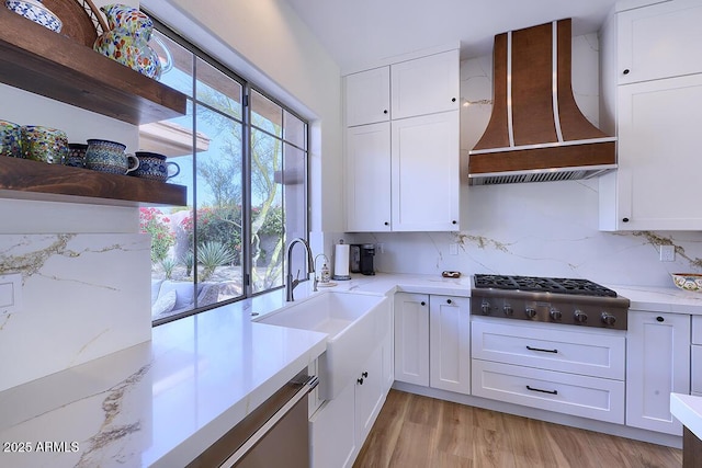 kitchen featuring white cabinetry, stainless steel gas stovetop, and wall chimney exhaust hood