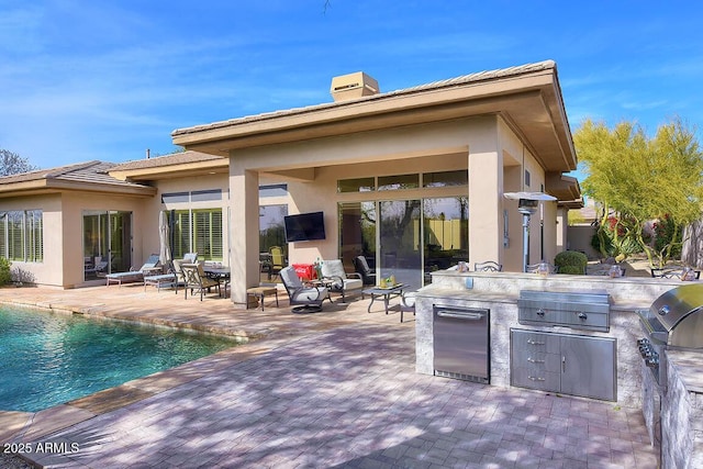 rear view of house featuring area for grilling and a patio area