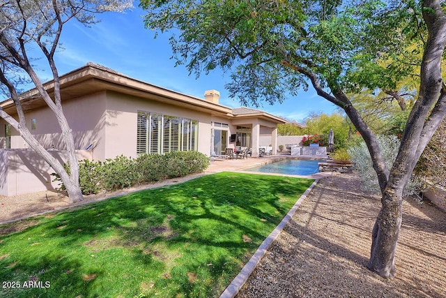 back of property with a patio and a lawn