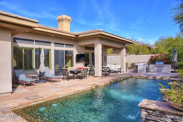 view of swimming pool featuring exterior kitchen and a patio