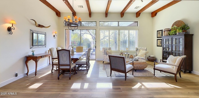 living area featuring beam ceiling, hardwood / wood-style floors, and a notable chandelier