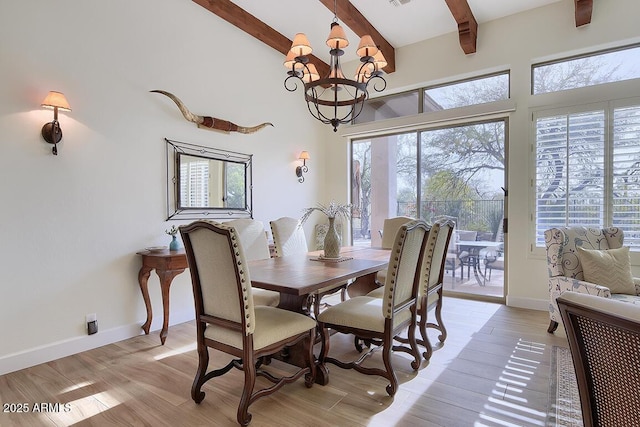 dining area with beam ceiling, light hardwood / wood-style floors, and a chandelier