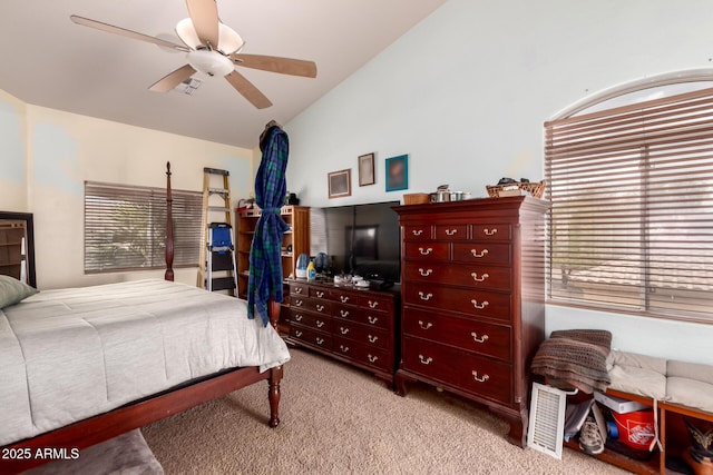 bedroom featuring vaulted ceiling, multiple windows, a ceiling fan, and light carpet