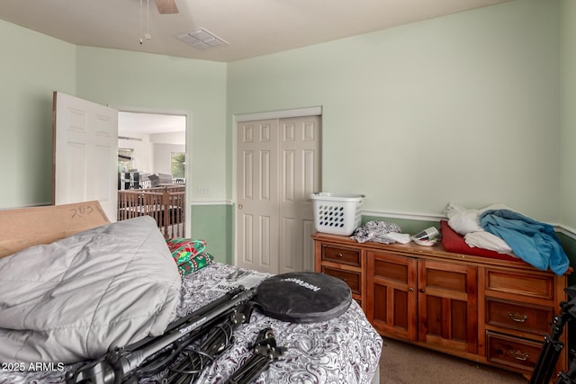 carpeted bedroom with visible vents, a closet, and ceiling fan