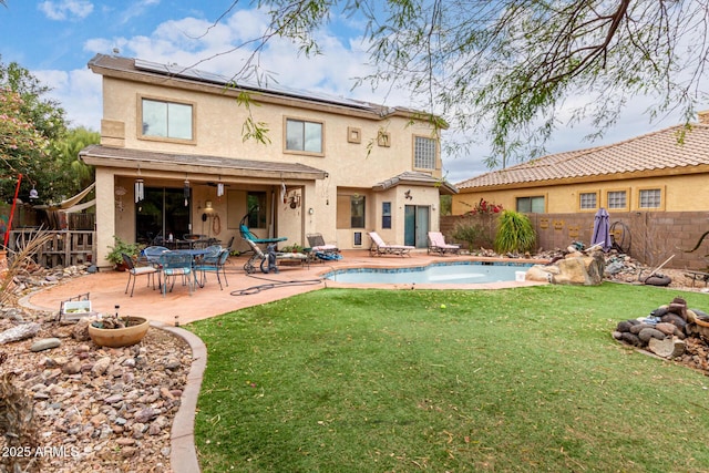 back of house with a patio, a fenced backyard, a lawn, and stucco siding