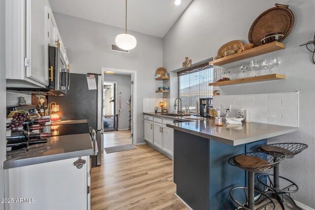 19930 N 98th Ave, Peoria, AZ 85382 - kitchen with stainless steel microwave, high vaulted ceiling, a sink, open shelves, and backsplash