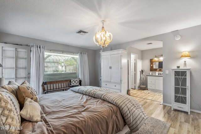 19930 N 98th Ave, Peoria, AZ 85382 - bedroom with arched walkways, a chandelier, light wood-style floors, ensuite bath, and baseboards