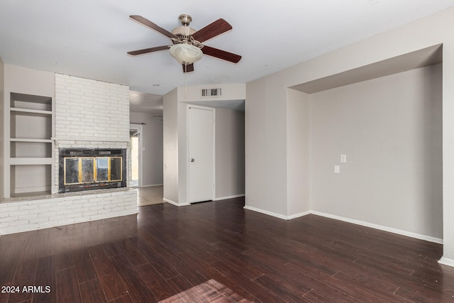 unfurnished living room with a fireplace, ceiling fan, built in features, and dark wood-type flooring