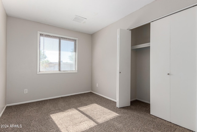 unfurnished bedroom with carpet and a closet