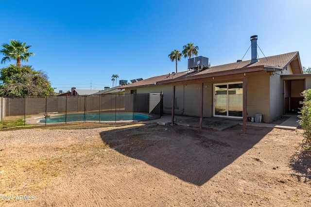 back of house featuring a fenced in pool and cooling unit