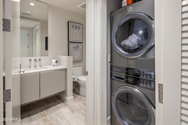 15215 N Kierland Blvd Unit 101, Scottsdale, AZ 85254 - laundry room featuring stacked washer / drying machine and light wood finished floors