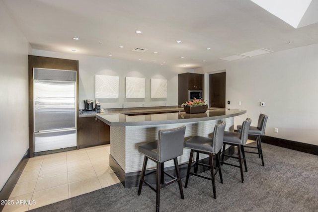 15215 N Kierland Blvd Unit 101, Scottsdale, AZ 85254 - kitchen with stainless steel built in refrigerator, a kitchen breakfast bar, dark brown cabinets, a kitchen island, and modern cabinets