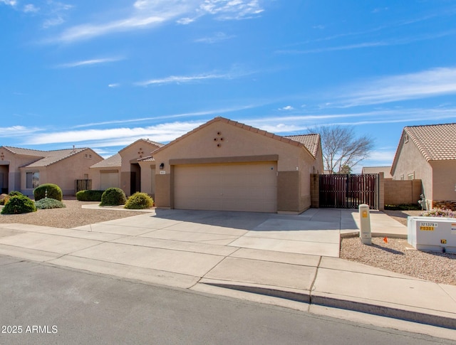 view of front of home featuring an attached garage, a tile roof, concrete driveway, a residential view, and stucco siding