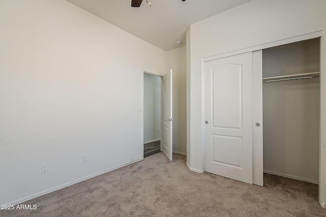 unfurnished bedroom featuring carpet floors, a ceiling fan, baseboards, and a closet