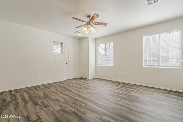 unfurnished room featuring baseboards, wood finished floors, visible vents, and a ceiling fan